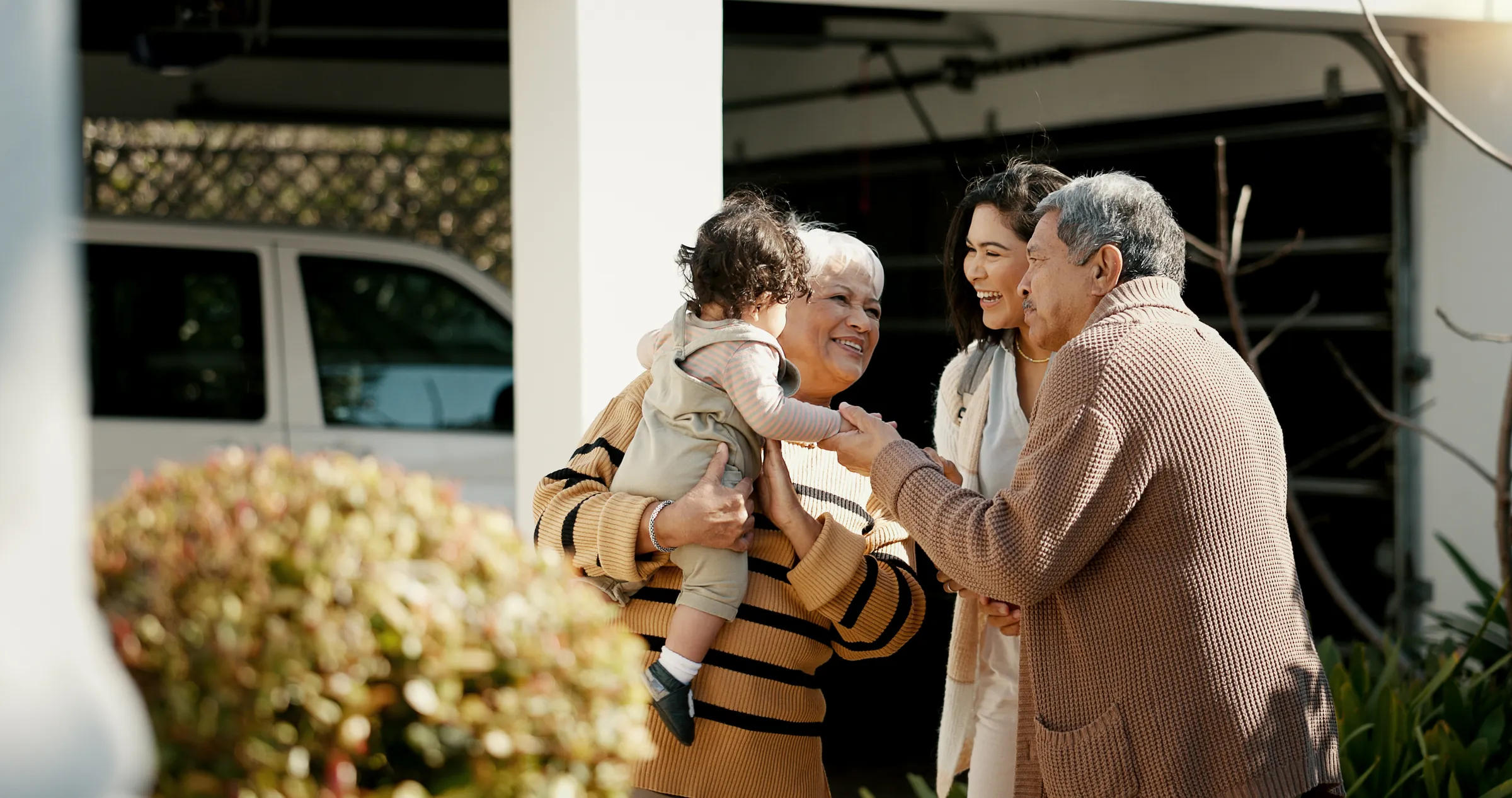 Family greeting their grandparents outside the house