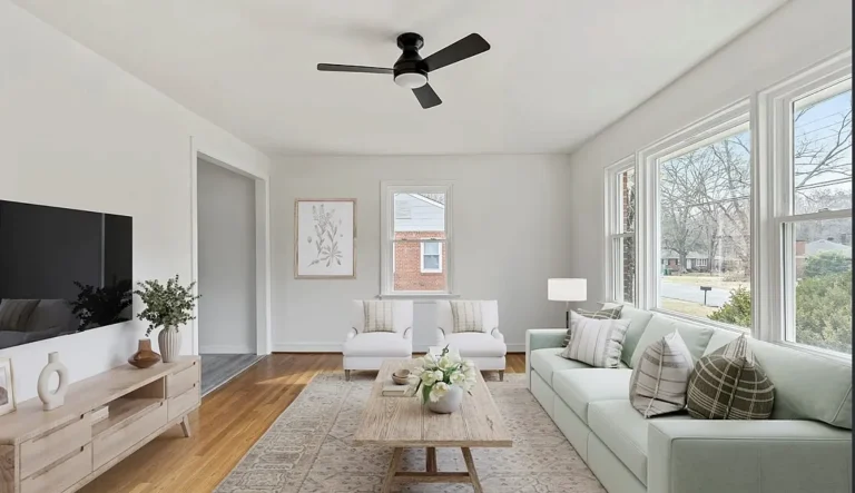 Renovated living room with a gray sofa, wood floors and large windows